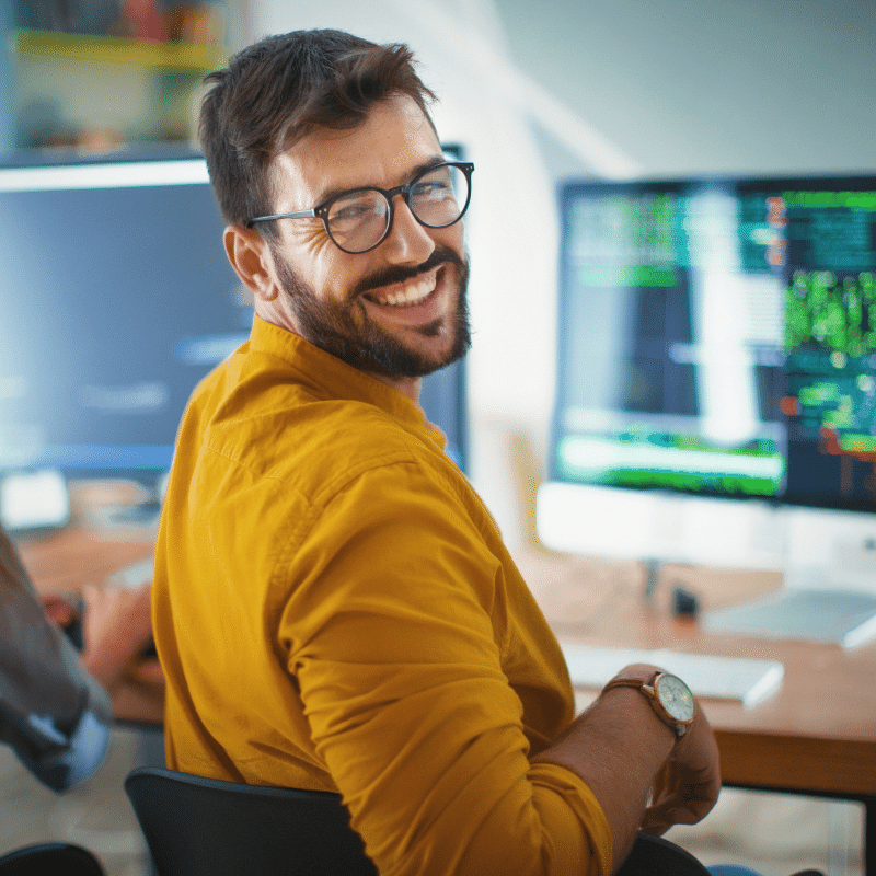 Man smiling next to laptop