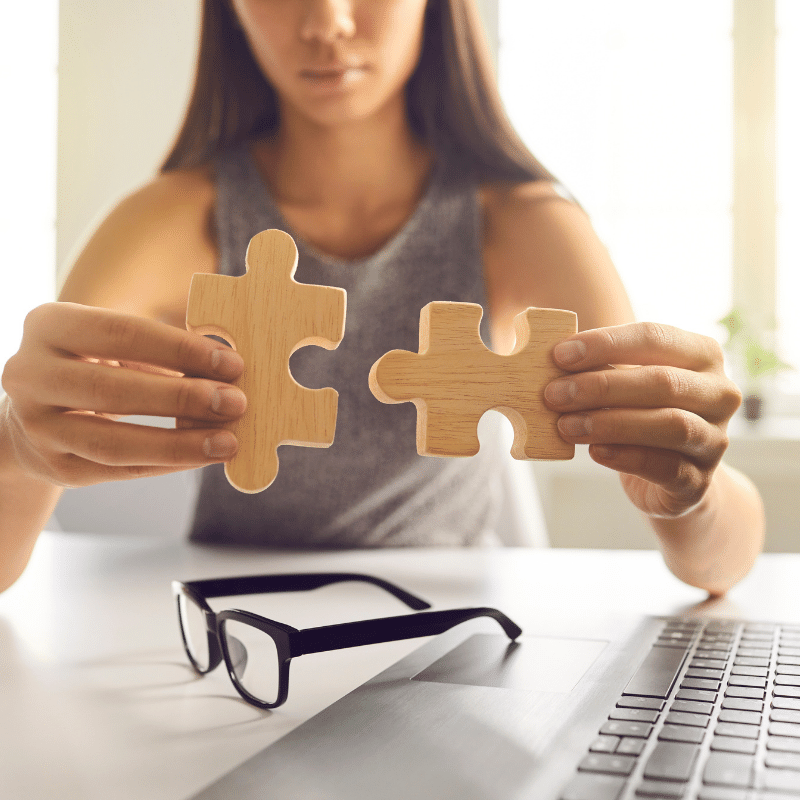 Woman holding wooden jigsaw pieces